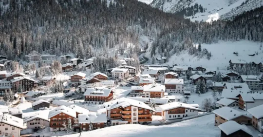 Persona trabajando durante la temporada de invierno en los Alpes franceses, rodeada de paisajes nevados de montaña.